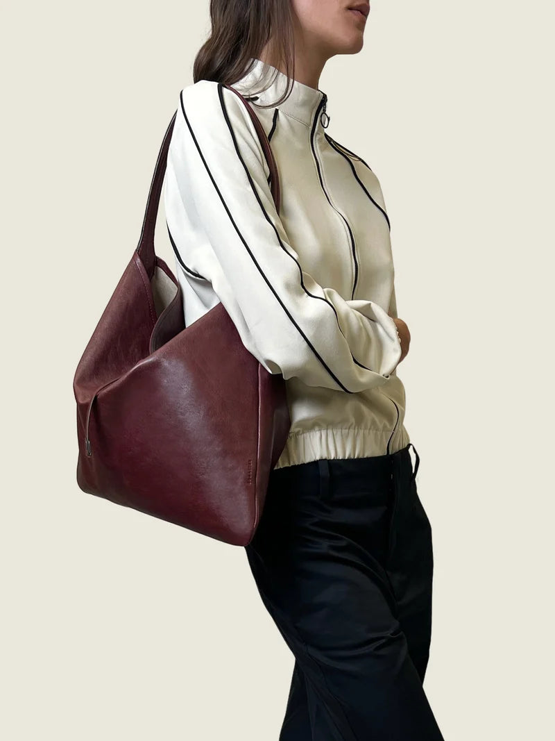 The burgundy leather tote carried on the shoulder, front view