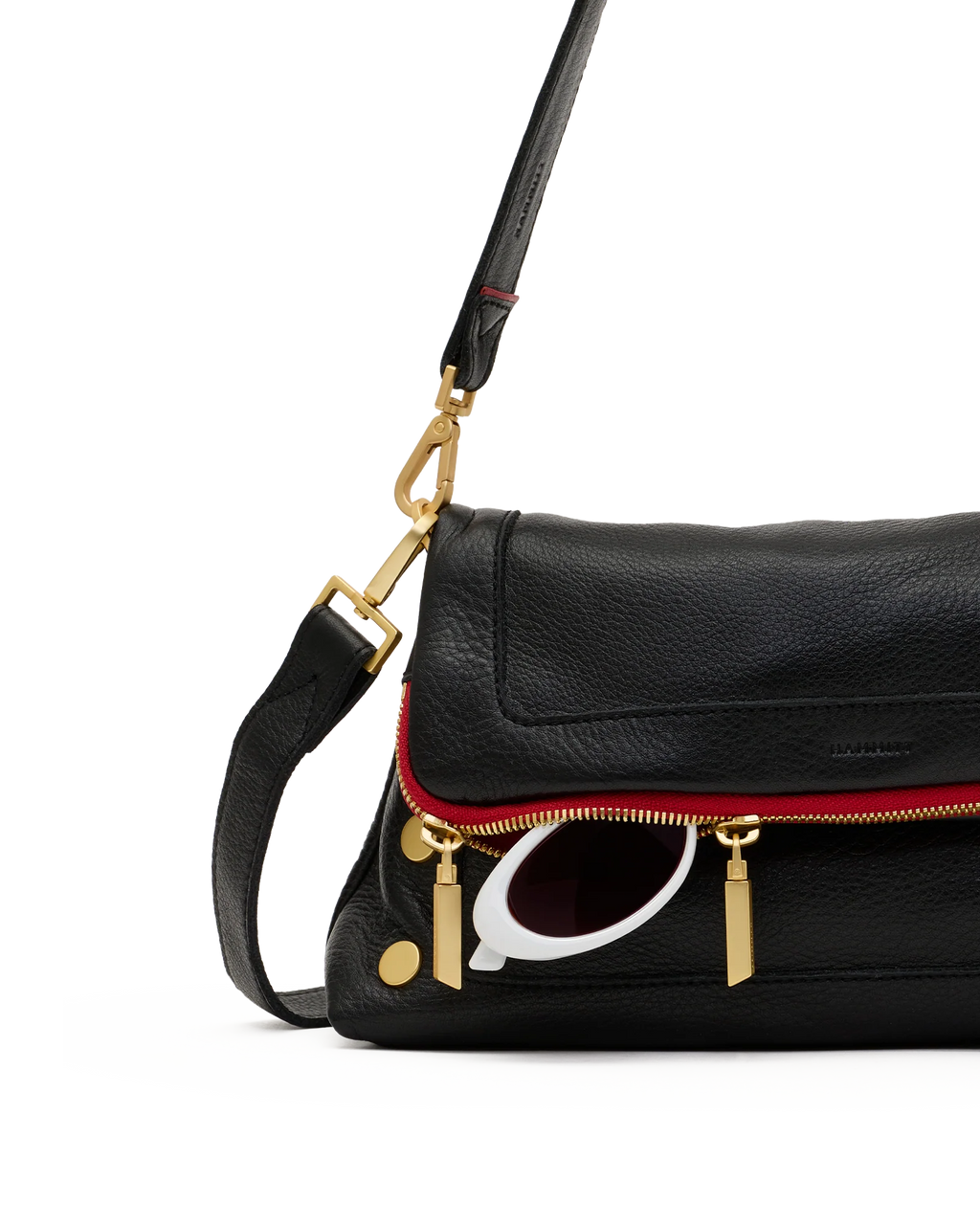Detail of the fold-over flap, red zip and gold zip pulls