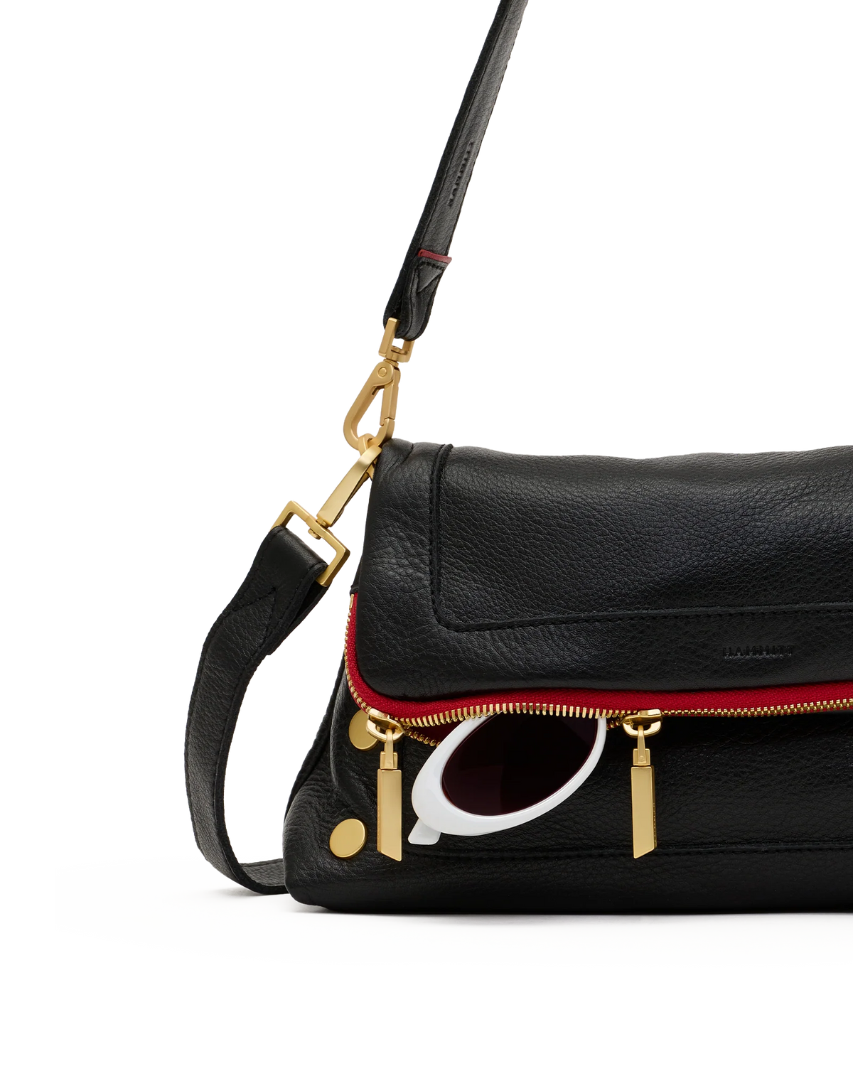 Detail of the fold-over flap, red zip and gold zip pulls