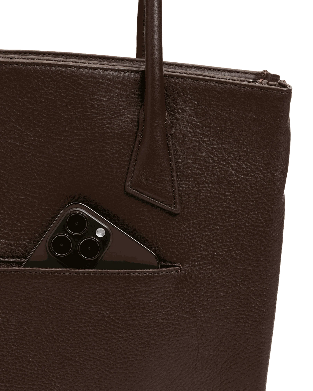 Close-up of the brown tote's front drop pocket holding a phone