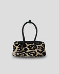 The Cila Cow Print Bag, front view with black double top handles