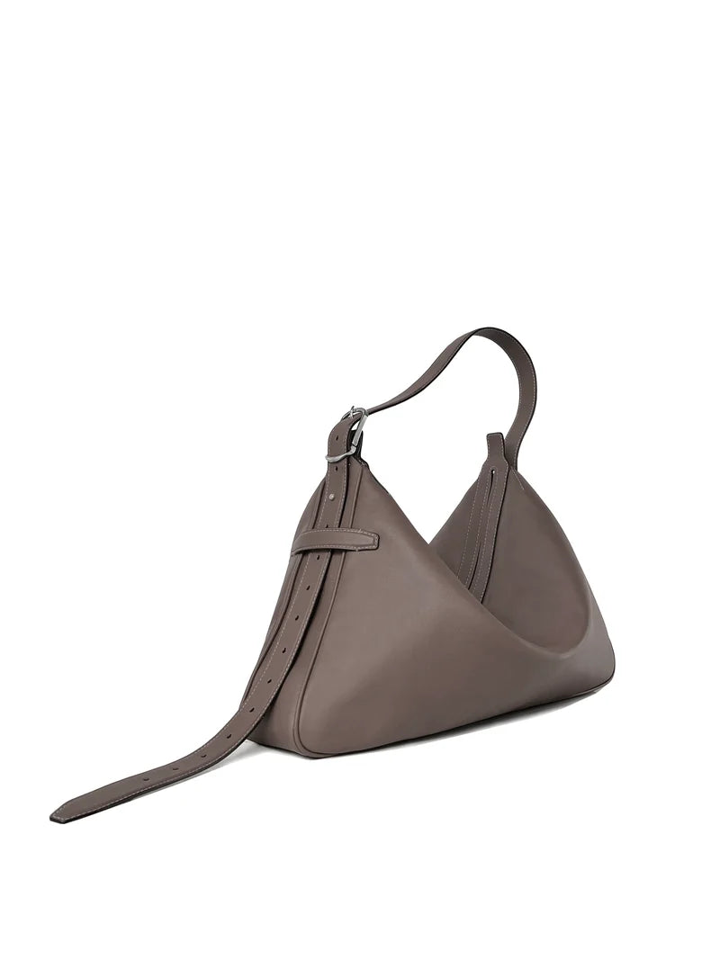 Taupe leather shoulder bag, three-quarter view showing the zip top and buckle strap