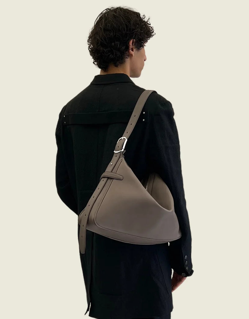 The taupe leather bag worn on the shoulder, seen from behind