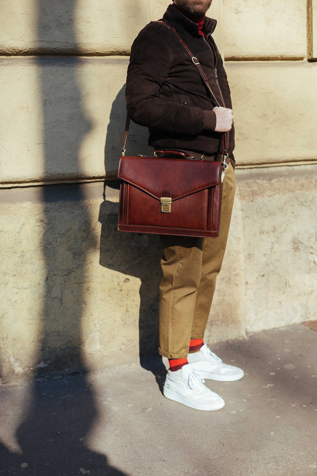 The briefcase worn on its detachable leather shoulder strap